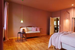 a bedroom with a bed and a chair with pink pillows at Ferienhaus Monteverde in Meddersheim