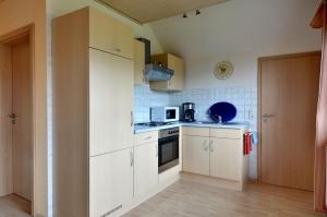 a kitchen with white cabinets and a stove top oven at Ferienwohnung Nationalparkblick in Altenlotheim