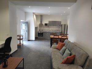 a living room with a couch and a kitchen at Casa da Mina in Mina do Bugalho
