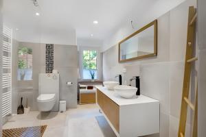 a white bathroom with two sinks and a mirror at Landhaus Schwerin in Kirch Jesar +49 photos