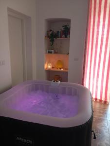 a bath tub with purple water in a room at Maison Valentina in Monopoli +34 photos