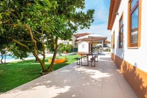 a patio with a table and chairs next to a yard at Casa das Laranjas in Murtosa