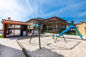 a playground in front of a house with a slide at Casa das Laranjas in Murtosa