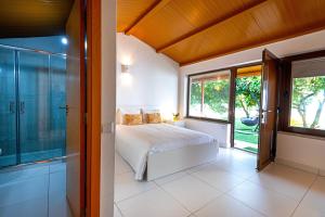 a bedroom with a bed and a large window at Casa das Laranjas in Murtosa