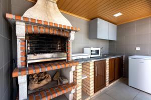 a kitchen with a brick oven in the middle at Casa das Laranjas in Murtosa