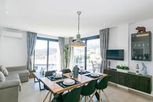 a living room with a table and chairs and a couch at Spacious apartment in Cómpeta in Cómpeta