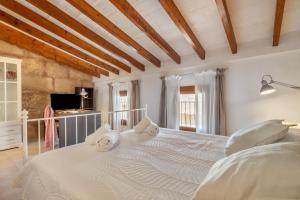 a bedroom with a large white bed with towels on it at Ca na Francesca in Pollença