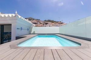a swimming pool on the roof of a house at Spacious apartment in Cómpeta in Cómpeta