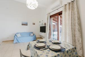 a dining room with a table and a couch at Villetta Marettimo Cornino in Custonaci