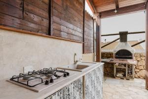 a kitchen with a stove and a sink at Villetta Marettimo Cornino in Custonaci