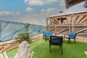 a patio with chairs and a table with a mountain in the background at Villetta Marettimo Cornino in Custonaci