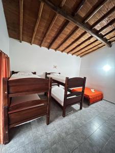 a room with two bunk beds and a table at Alegría Lodge in Curití