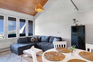 a living room with a blue couch and a table at Schwarzwaldtraum in Sasbachwalden