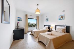 a bedroom with two beds and a balcony at Chez Hélène et Paulo - Lagos in Lagos +24 photos