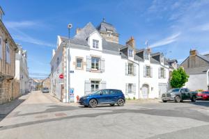 a blue car parked in front of a white building at Martin - Appartement Le Croisic in Le Croisic