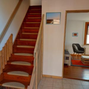 a staircase in a house with a living room at Ferienhaus Hadler in Kaiser Wilhelm Koog