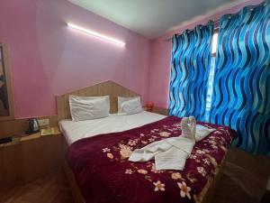 a bedroom with a bed with a pair of shoes on it at CL Villa Manali in Manāli