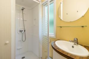 a bathroom with a sink and a shower at Mobilhome Le Chataignier in Saint-Pompont +14 photos