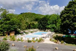 an overhead view of a swimming pool with umbrellas at Mobilhome Le Chataignier in Saint-Pompont