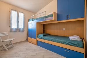 a bedroom with two bunk beds and a chair at Baia delle mimose vista mare in Badesi