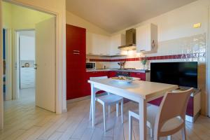 a kitchen with a white table and chairs at Baia delle mimose vista mare in Badesi +17 photos