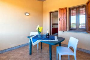a blue table with a vase of flowers on it at Baia delle mimose vista mare in Badesi