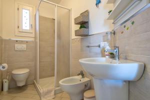 a bathroom with a sink and a toilet and a shower at Baia delle mimose vista mare in Badesi