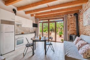 a kitchen and living room with a table and a couch at Can Garraseca in Llucmajor