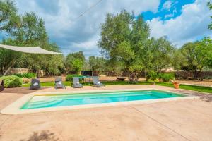 a swimming pool with two chairs and a table at Can Garraseca in Llucmajor