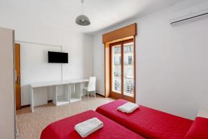 a white room with a red bed and a desk at Appartamento il Sentiero degli Dei in Agerola