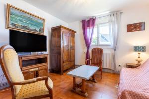 a living room with a television and a table and chairs at Villa Nicole face mer in Trégunc