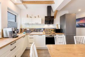 a kitchen with white cabinets and a stainless steel refrigerator at Fewo Landblick Geiseltal in Braunsbedra