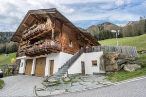 a wooden house with a balcony on the side of it at Ferienhaus Pichlerhof in Fundres