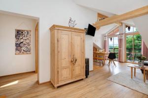 a room with a wooden door and a dining room at Neubau - Freundliche Fewo Bergblick in Höslwang