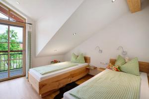 two beds in a room with a window at Neubau - Freundliche Fewo Bergblick in Höslwang
