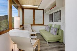 a living room with a green couch and a chair at Sonnenblick in Lenzkirch +23 photos