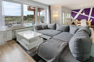 a living room with a couch and a large window at Sonnenblick in Lenzkirch