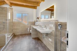 a bathroom with two sinks and a shower at Cosy Home Allgäu in Haldenwang +12 photos