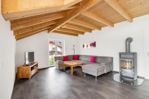a living room with a couch and a fireplace at Cosy Home Allgäu in Haldenwang
