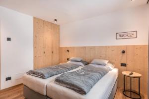 two beds in a room with wooden walls at Apartement Franzl in San Vigilio Di Marebbe