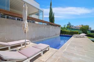 a pool with two lounge chairs and an umbrella at Sweet Home Albufeira in Albufeira