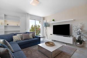 a living room with a blue couch and a tv at Sweet Home Albufeira in Albufeira