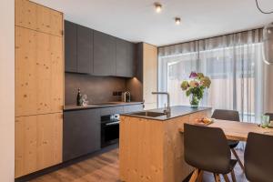 a kitchen with wooden cabinets and a table with chairs at Apartement Franzl in San Vigilio Di Marebbe
