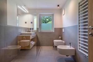a bathroom with two sinks and a toilet and a window at Apartement Franzl in San Vigilio Di Marebbe +18 photos