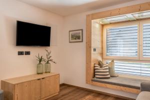 a living room with a window seat and a flat screen tv at Apartement Franzl in San Vigilio Di Marebbe