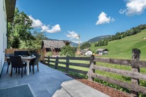 a patio with a table and chairs and a fence at Apartement Franzl in San Vigilio Di Marebbe