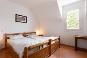 a bedroom with a wooden bed with a window at Escapade Sérénité - Les Alignements in Carnac