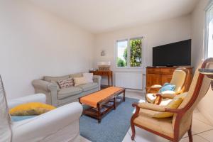 a living room filled with furniture and a flat screen tv at Escapade Sérénité - Les Alignements in Carnac