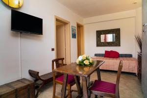a living room with a table and a bed at Garden Cottage I Dammusi - Arancio in Castelmola +11 photos