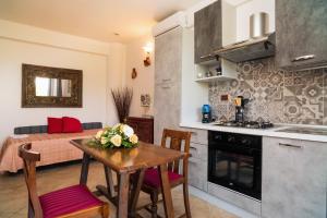 a kitchen and dining room with a table and a dining room at Garden Cottage I Dammusi - Arancio in Castelmola